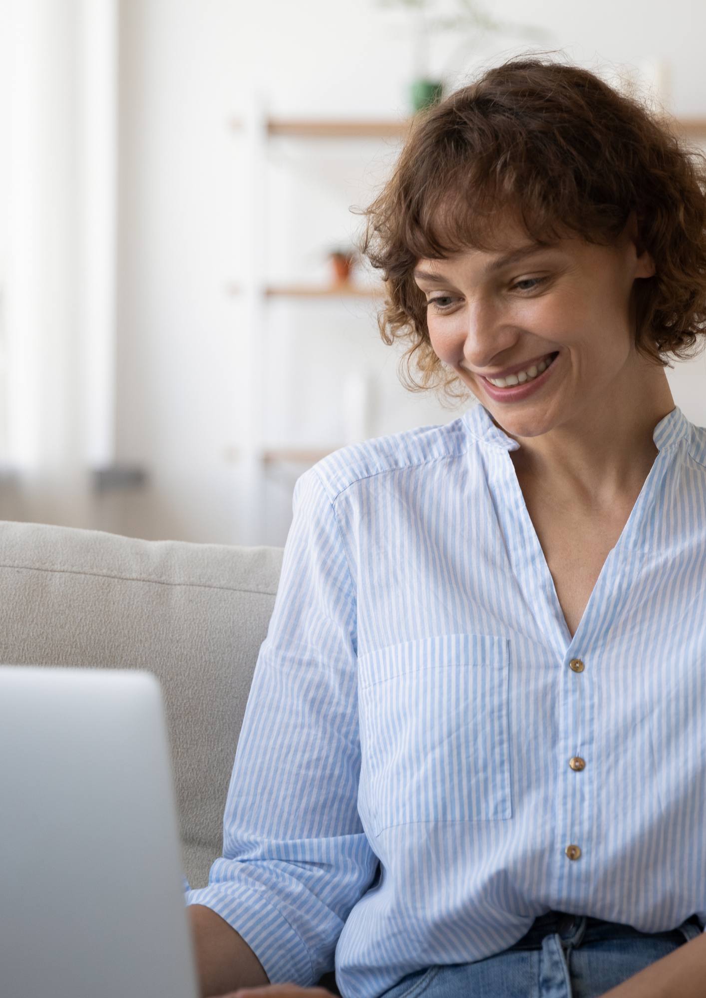 Smiling woman on a laptop, booking a telehealth psychology appointment