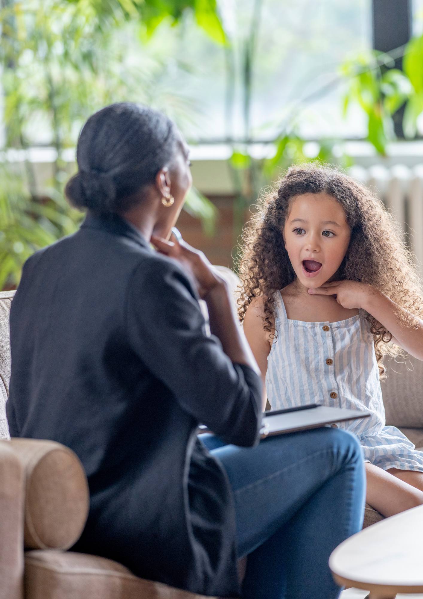 Psychologist listening to a young girl during a child therapy session